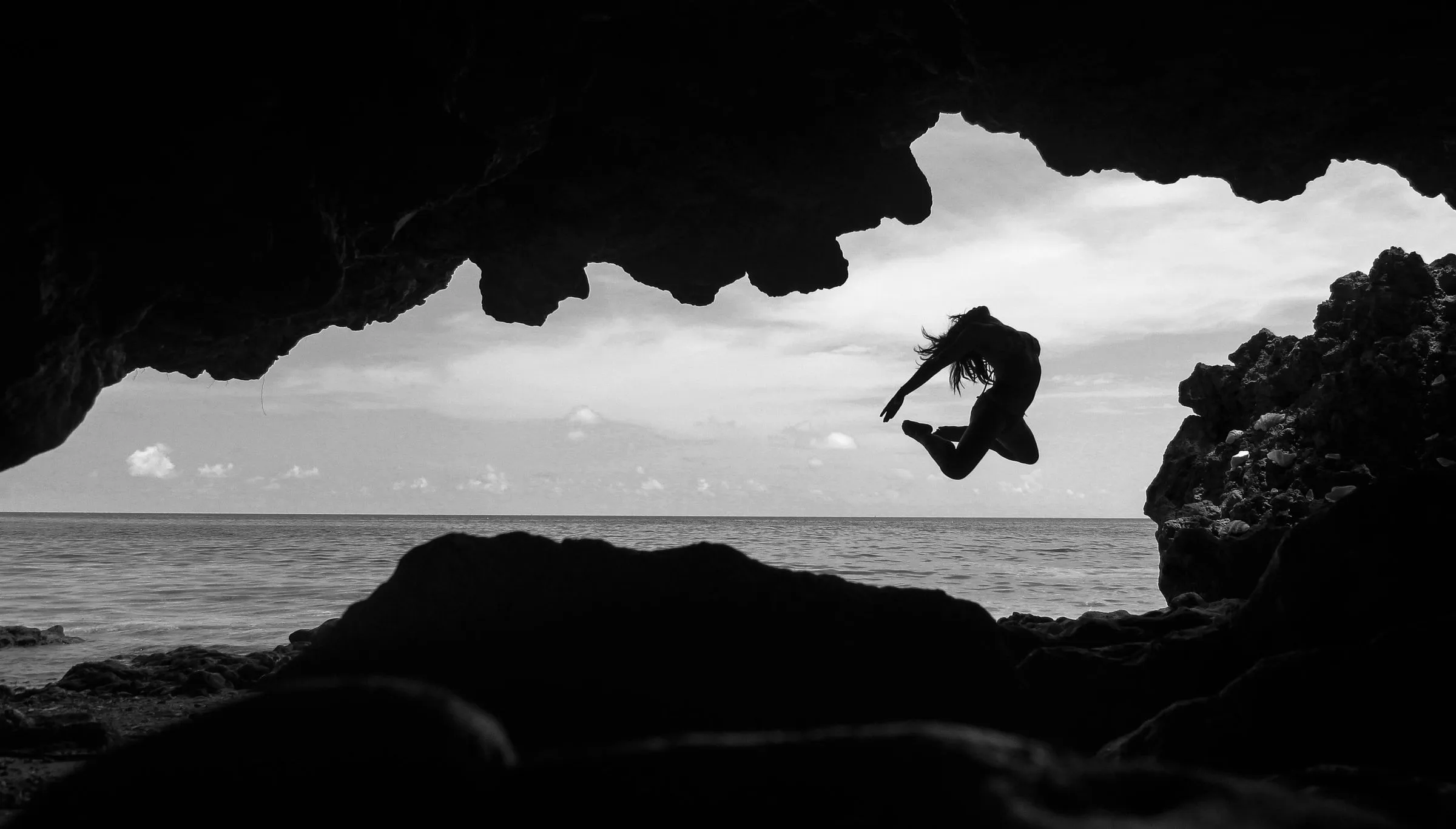 Silhouette of Gab leaping in a seaside cave