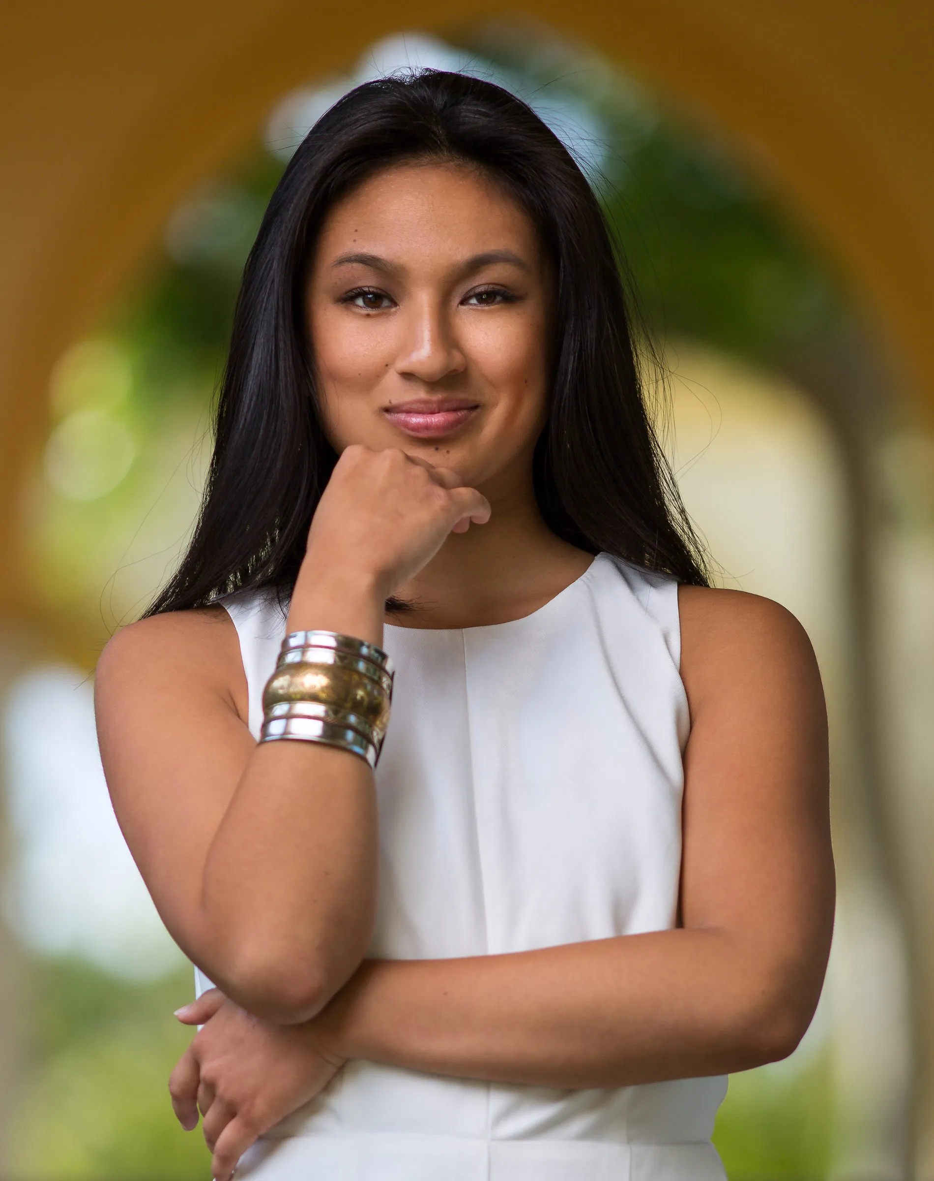 Portrait of Gab Ybiernas, hand at her chin, gold and silver cuffs on her wrist
