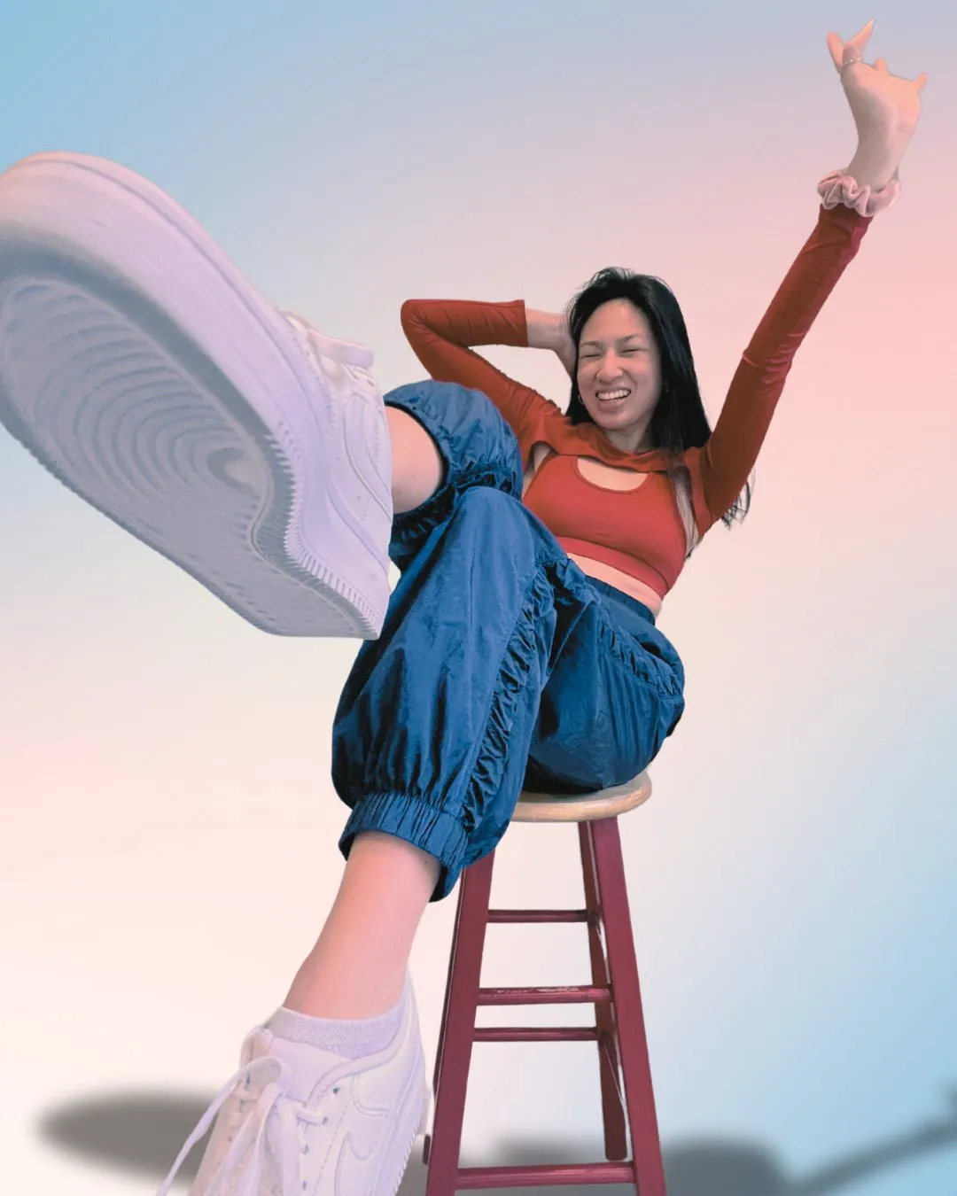 Gab kicking toward the camera in a studio, laughing